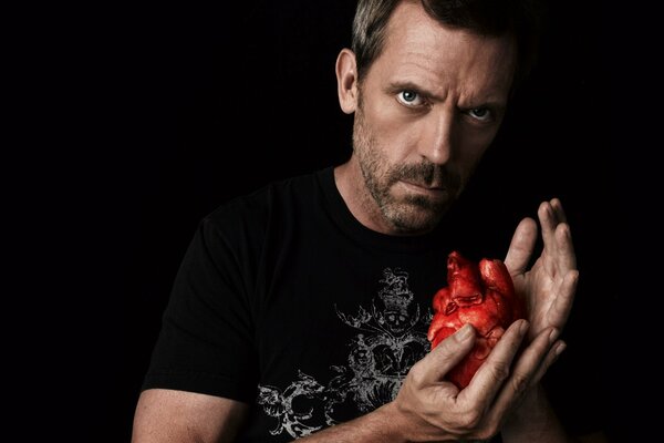 A red heart in the hands of a man