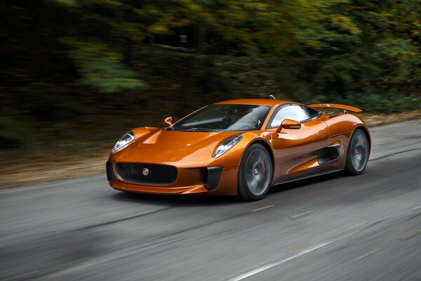 Orange Jaguar spectre drives fast on the road