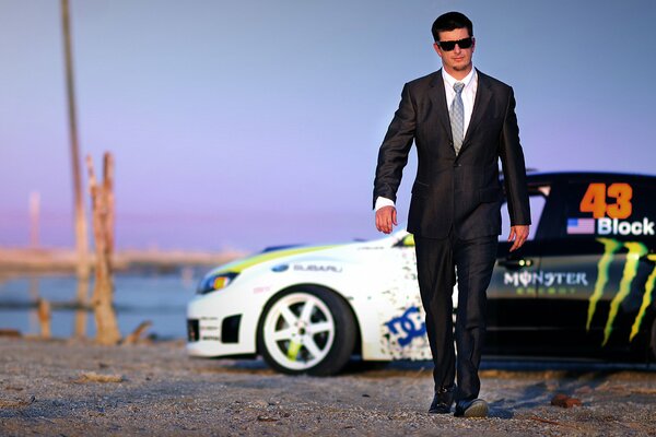 A man in a suit on the background of a car