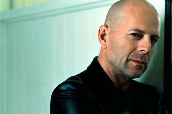 Bruce Willis con un sorriso sullo sfondo del muro