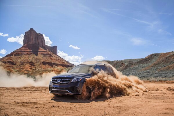 Mercedes among the sand dust in the canyon