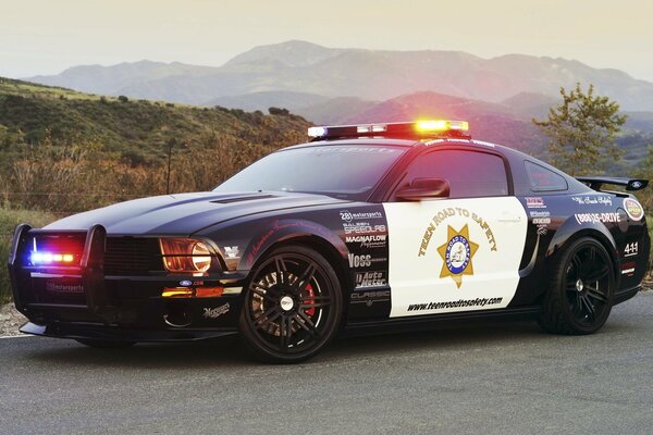 Coche de policía negro Mustang de pie en la carretera vista lateral