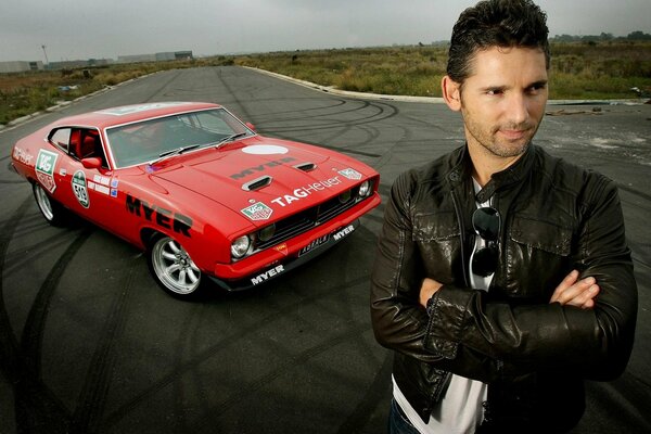 A man stands on the road against the background of a car