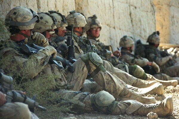 Soldaten ruhen sich an der Steinmauer aus