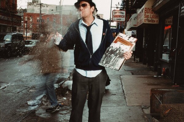 A man in a hat with records in his hands