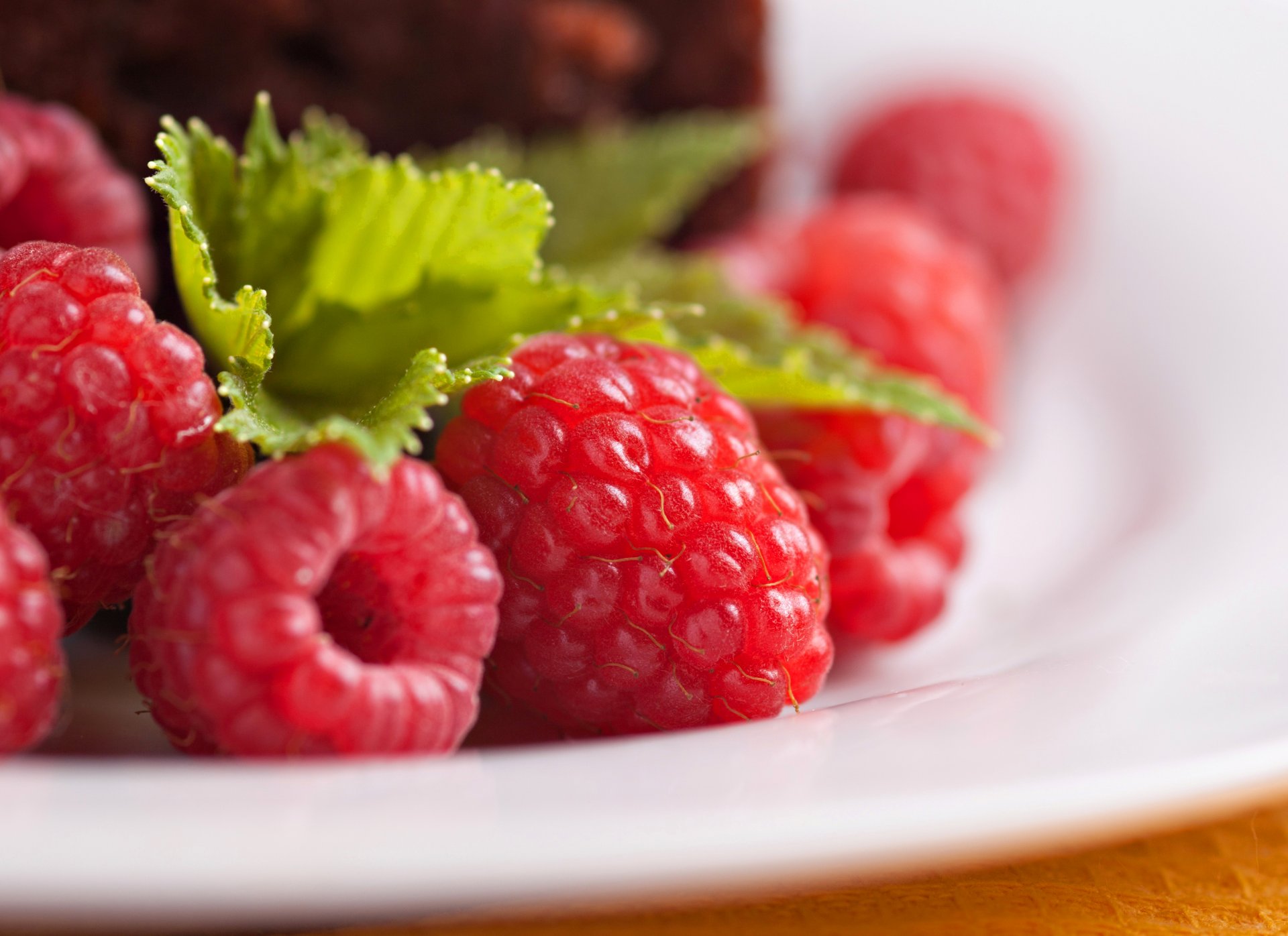 framboises baies rouges feuilles assiette