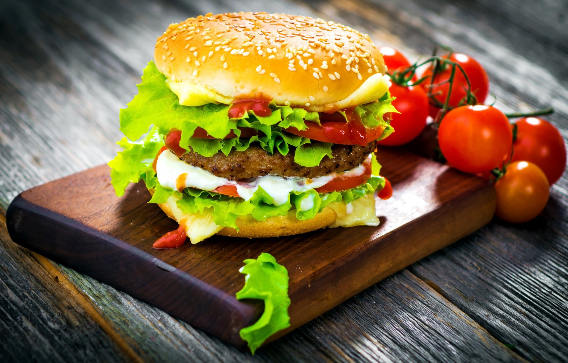 hamburger fast food roll sesame patty torment tomatoes vegetables salad leaves cheese board