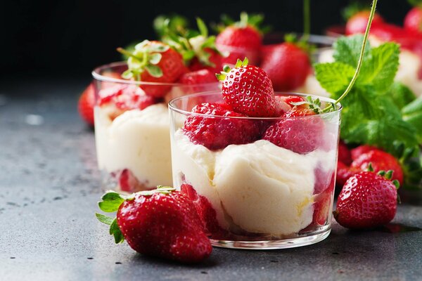 Ice cream in a glass glass with strawberries and mint