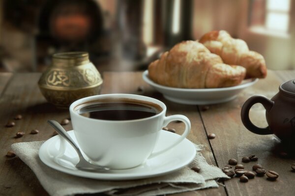 Still-life. A mug with a saucer. Croissants on a plate