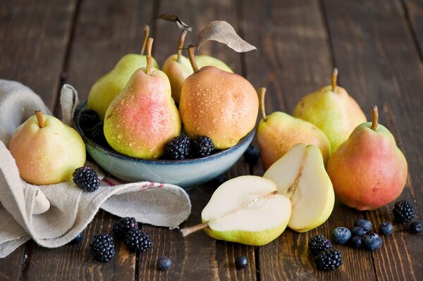 Peras y moras en una mesa de madera