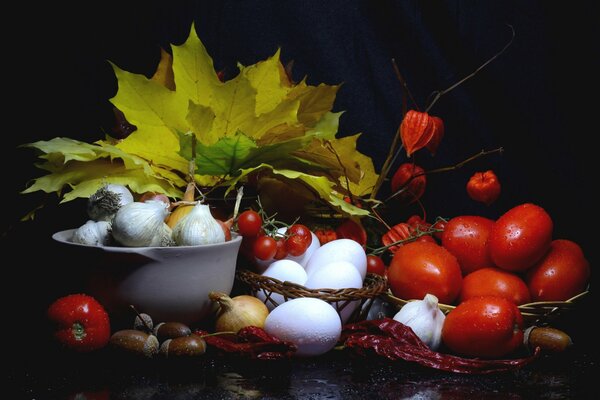 Natura morta con foglie autunnali e pomodori maturi