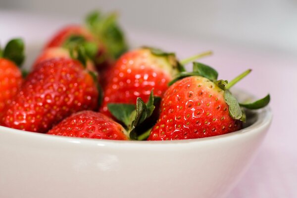 Fragole fresche, succose e mature in una tazza bianca