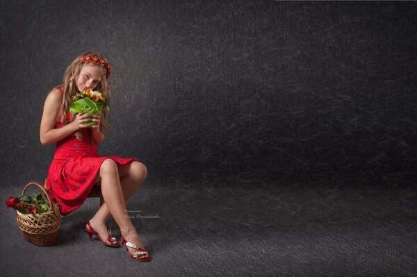 Jeune fille assise dans une robe avec un panier de fruits