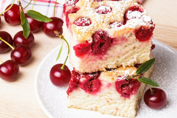 Kirschkuchen in Puderzucker und frische Beeren