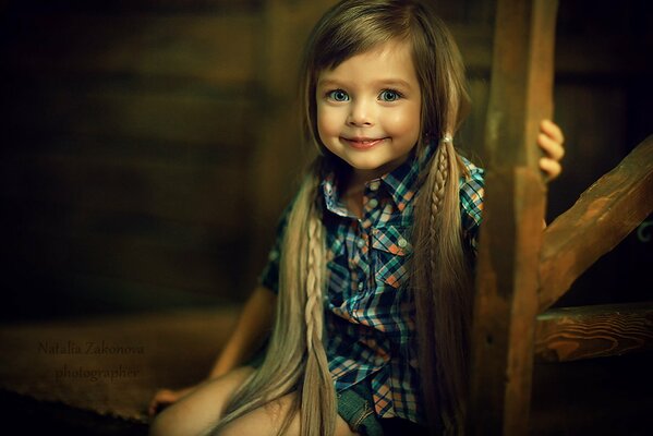 La niña con coletas sonríe. Bebé feliz
