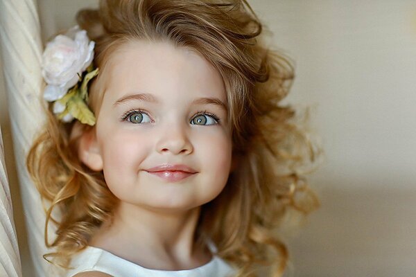 Ragazza con un fiore tra i capelli. Bel bambino