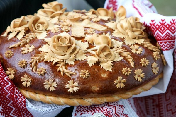 A loaf with flowers on a white towel with an ornament