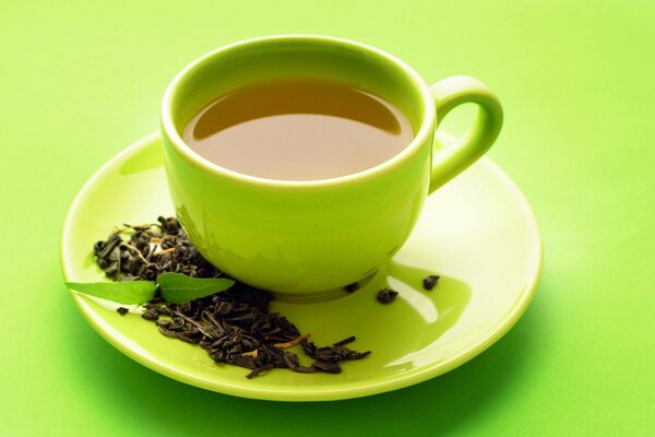 Tee in einer grünen Tasse auf grünem Hintergrund