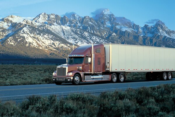 A truck on the road against the background of mountains