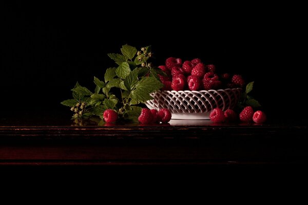 Stillleben mit Himbeeren in dunklen Farben