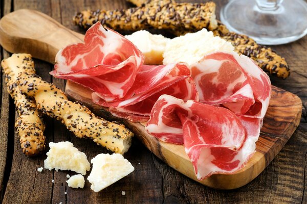 Plancia con taglio di carne, formaggio e baguette