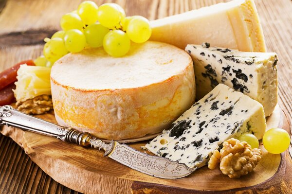 Cheese, grapes and a knife on a tray