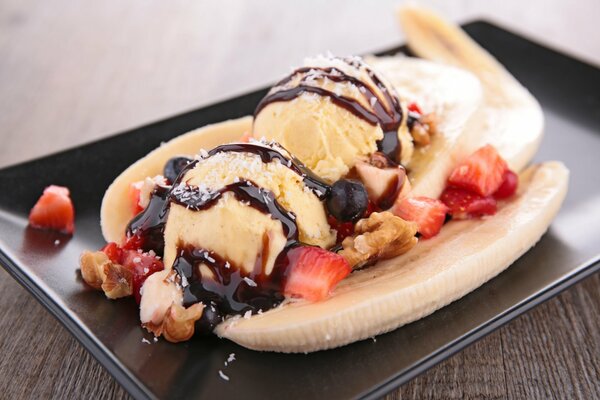 Postre de helado con plátano, fresa y chocolate