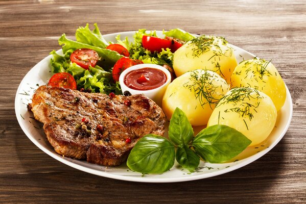 Plat avec pommes de terre rondes, steak et légumes verts