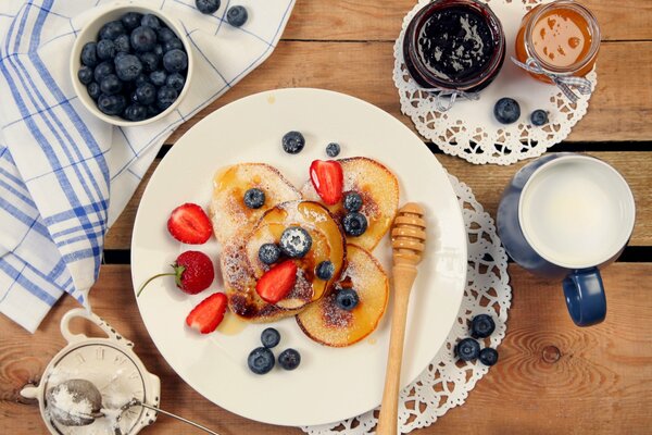 Pancakes on a plate with strawberries and jam