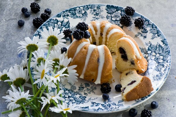 Teller mit Beerenkuchen und Blumen