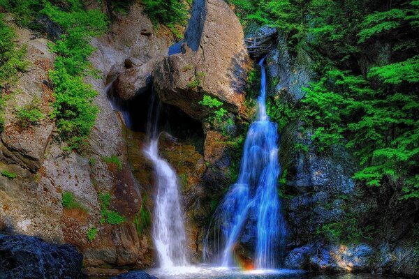 Cascate blu e bianco sullo sfondo di montagne e foreste