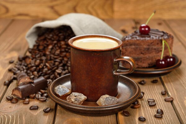 Grains de café, café et gâteau au chocolat sur fond en bois