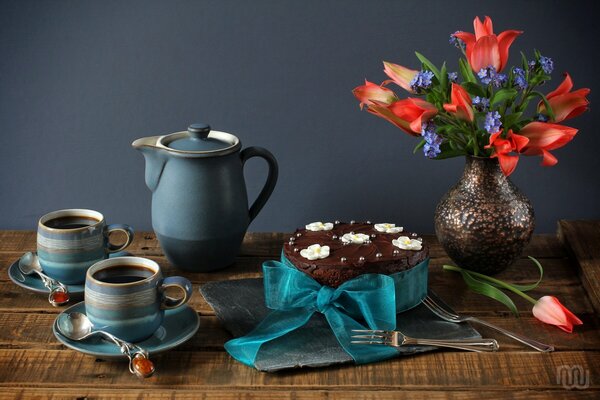 Bouquet de fleurs sur la table avec gâteau et thé