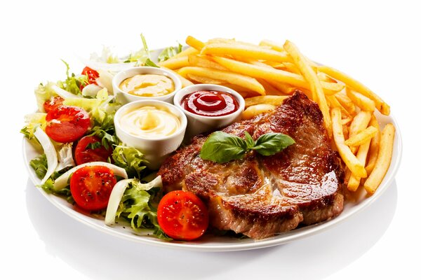 Gegrilltes Fleisch mit Gemüsesalat, Pommes Frites und drei Soßen auf einem weißen Teller