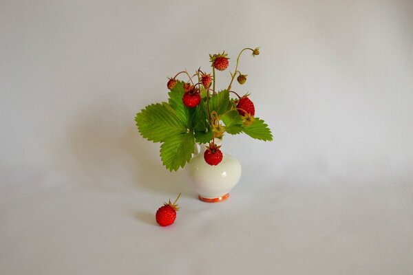 Still life with the image of a vase of strawberries