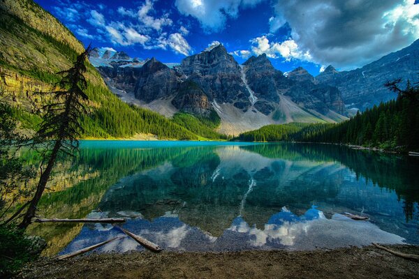 Berge und Wolken spiegeln sich im klaren Wasser des Bergsees wider