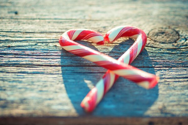 Cuore di caramelle su tavola di legno