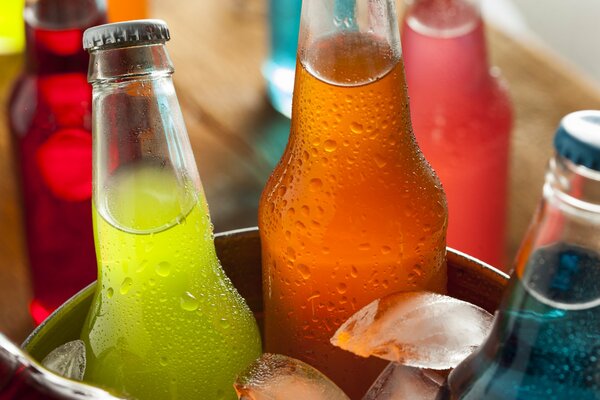 Botellas de bebidas multicolores en un cubo de hielo