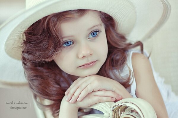 Hermosa chica con ojos azules. Niño con sombrero