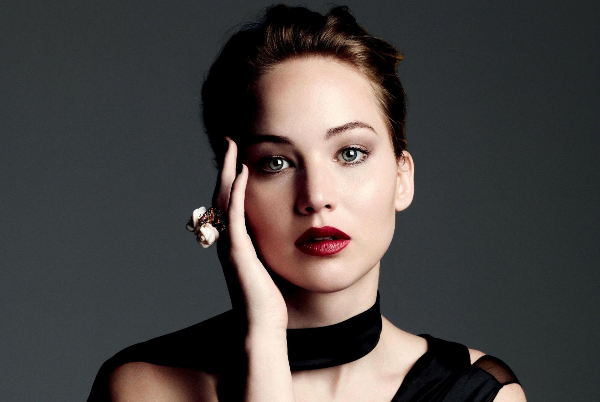 jennifer lawrence attrice ragazza viso ritratto trucco mano anello grigio sfondo