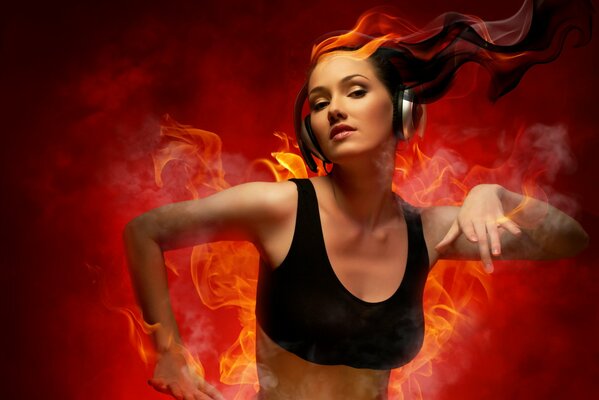 Dancing girl with headphones on the background of flames