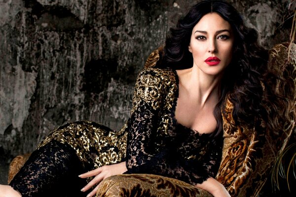 Monica Bellucci on a chair in a dress