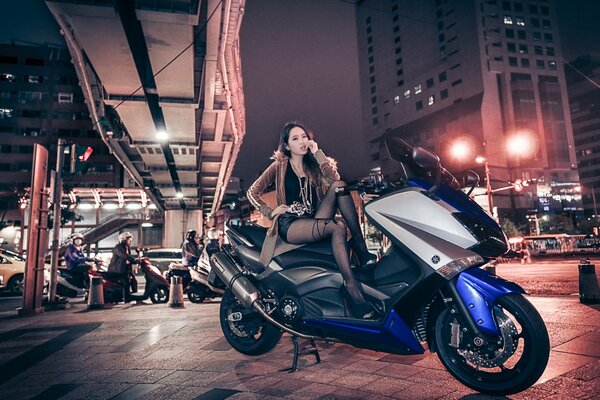 Cheeky girl on a motorcycle in the city