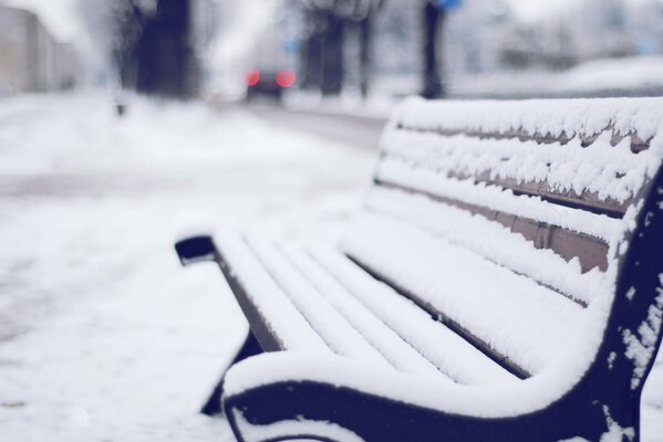 A winter bench standing alone by the road