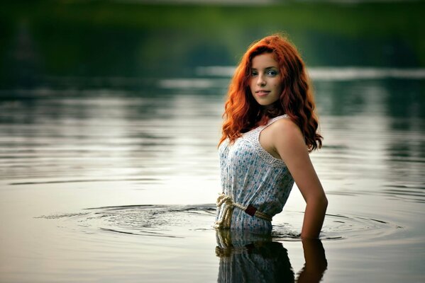 Fille Rousse dans l eau. Elle est montée dans l eau en robe. Photoshoot dans l eau