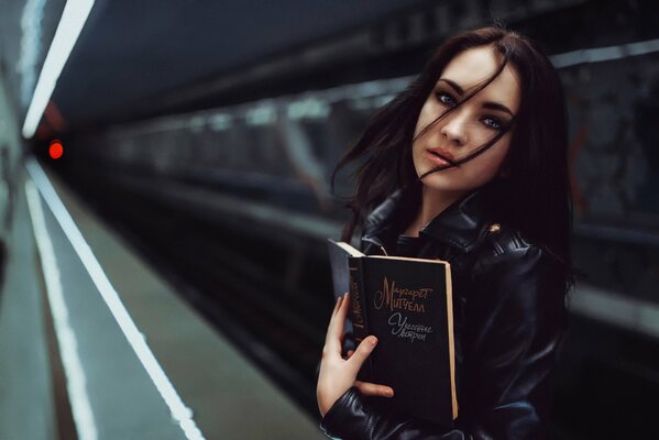 A girl in the subway with a book gone with the wind