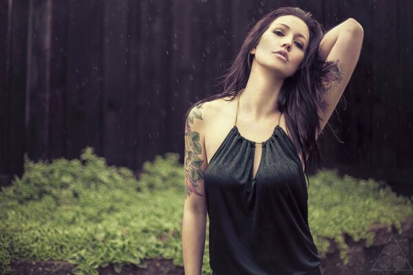 Modèle sous la pluie. Fille dans les tatouages