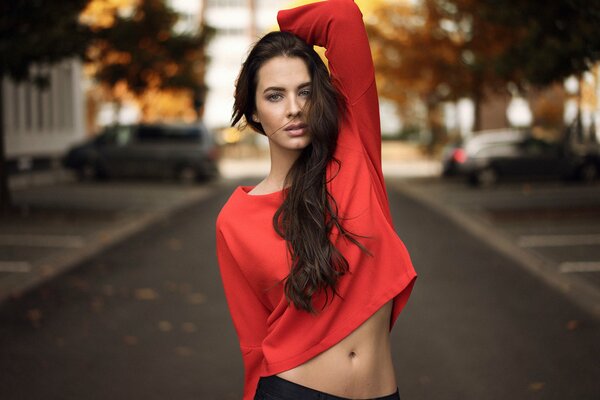 Belle photo de la jeune fille dans la rue vers le haut rouge