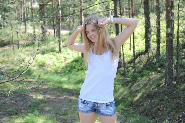 Modèles 2015. Fille en short et t-shirt blanc. Jeune fille dans la nature