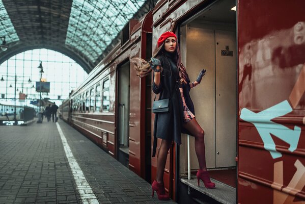 A girl in a red beret enters the carriage